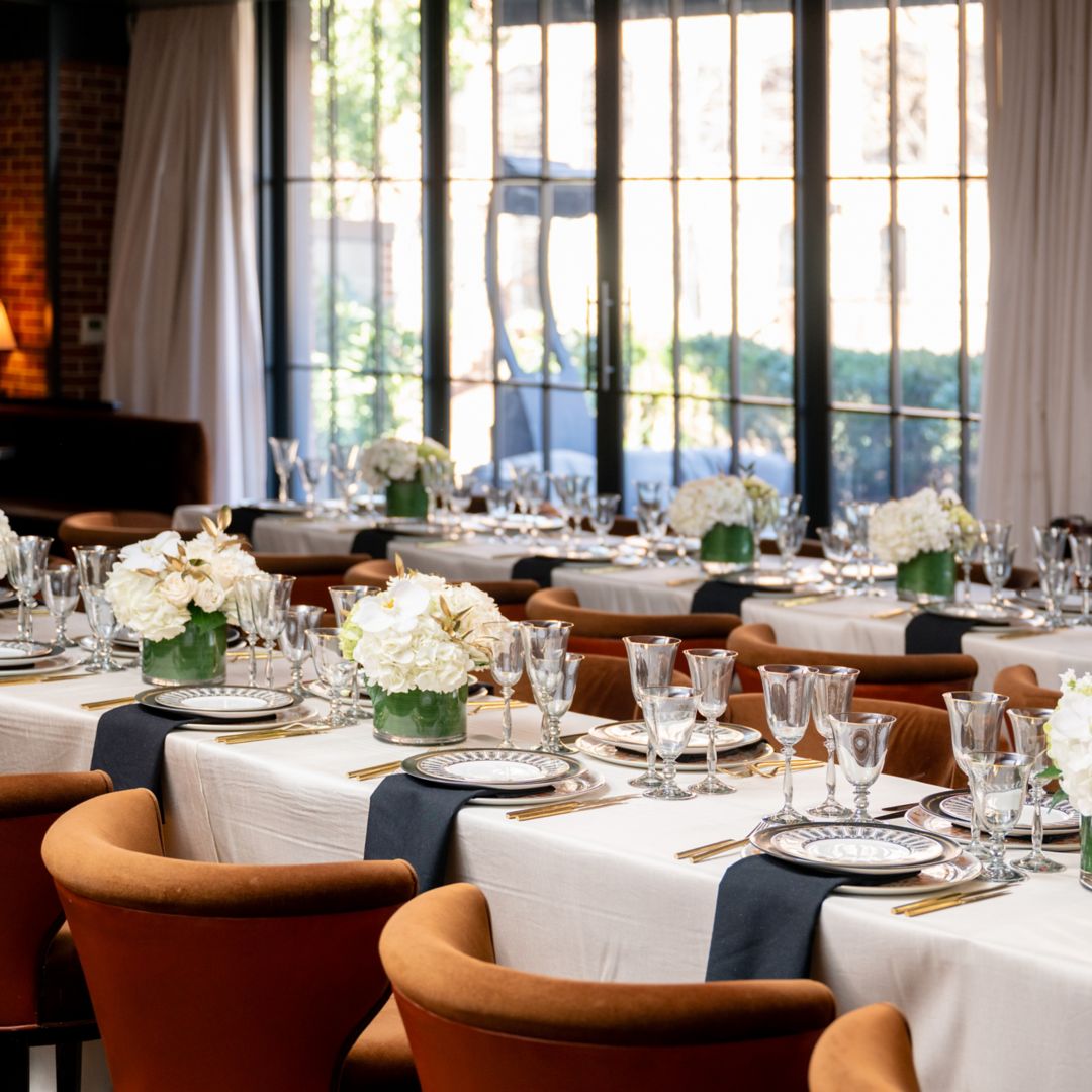 A formal dining setup with white tablecloths and floral centerpieces at an event venue in Washington, D.C.